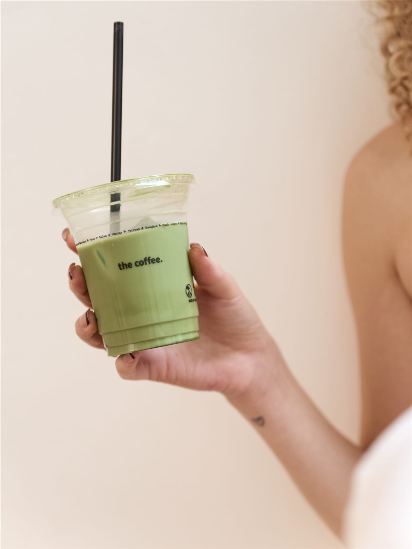 A hand holding a matcha from the coffee.