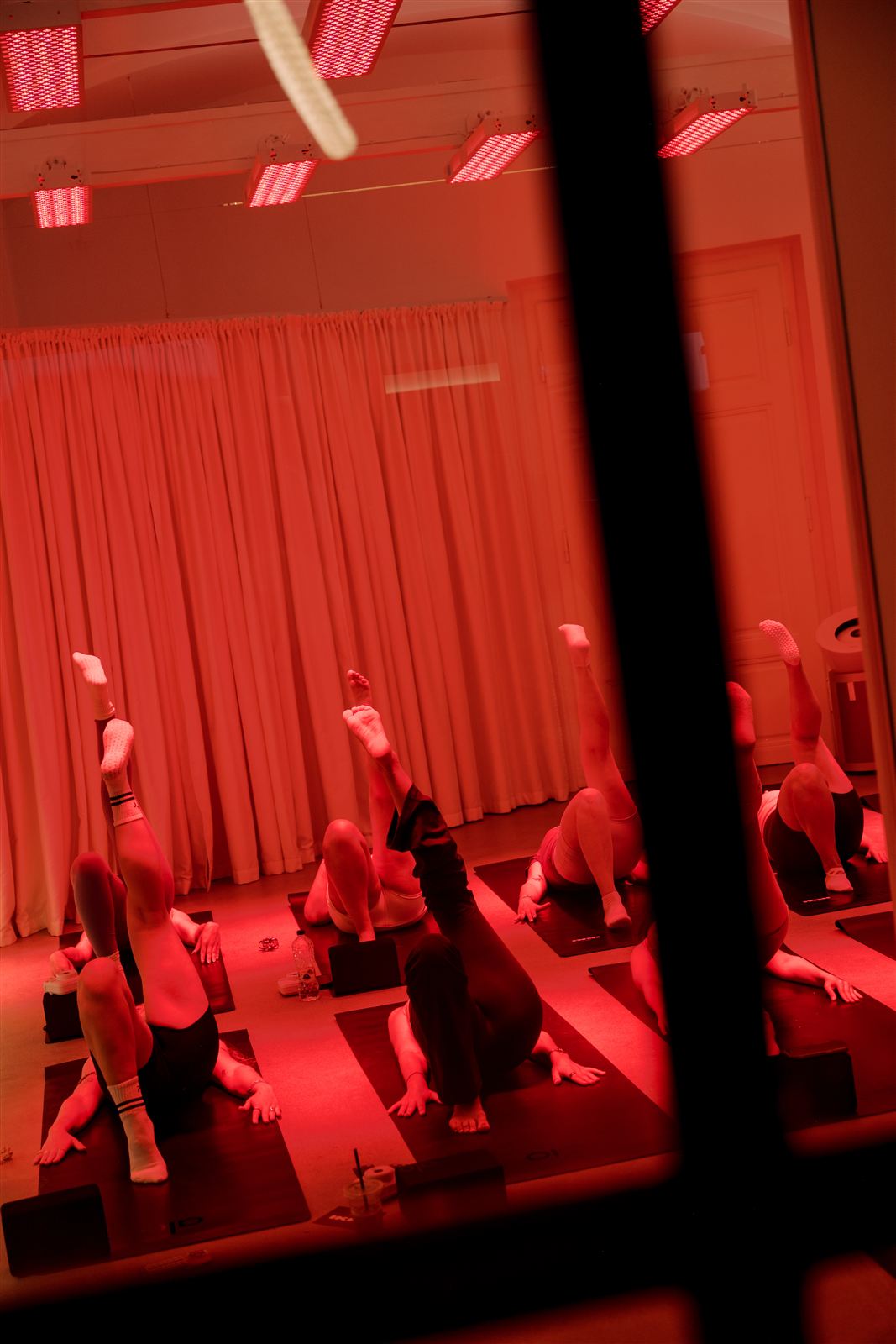 A class in session under red light, seen through a studio window